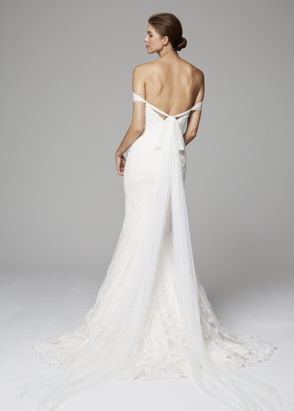 Refined mermaid gown of beaded embroidered lace with tulle off-the-shoulder drape extending to train.