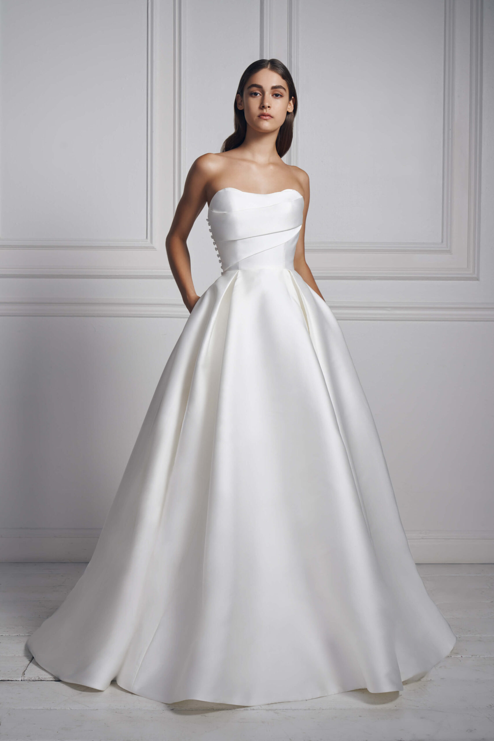 Strapless white silk ball gown by Anne Barge. This classic ball gown is adorned with buttons.
