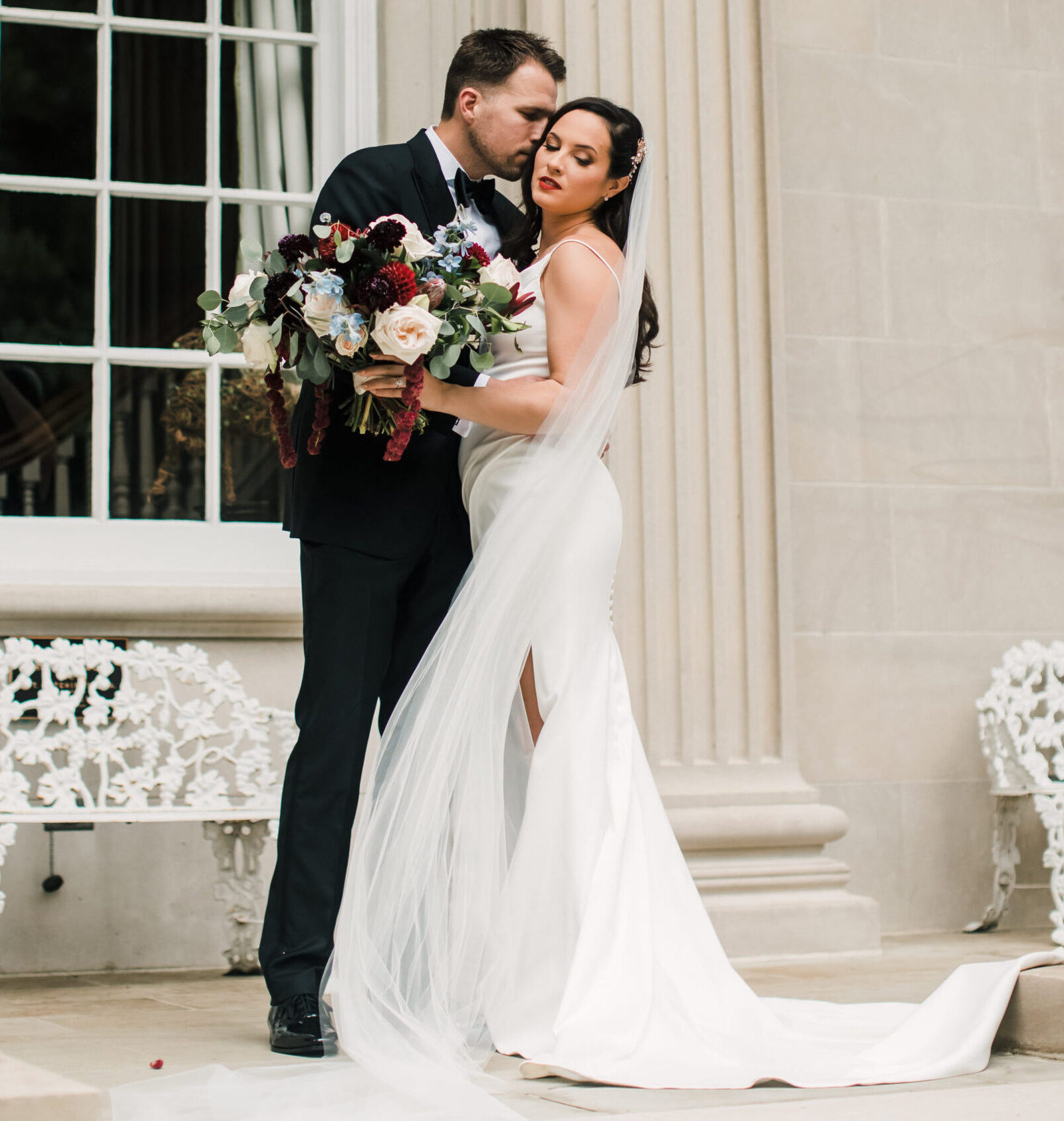 Bride looking down as husband leans in for kiss