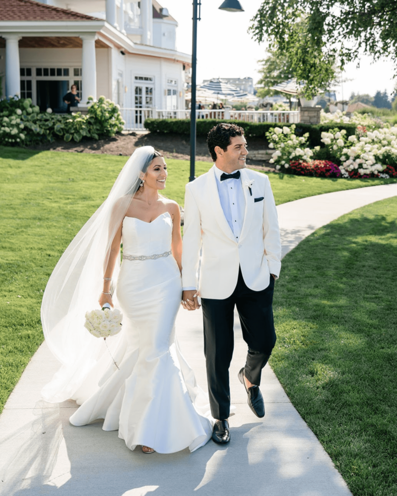 Bride standing alongside husband in a garden