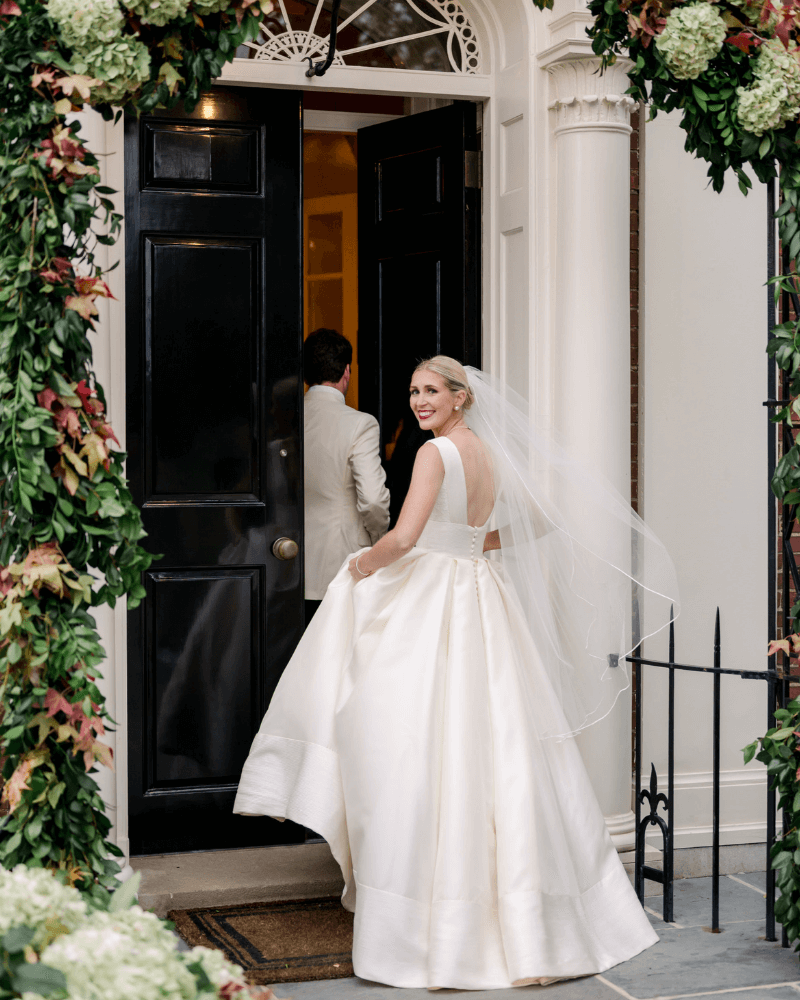 Bride looking over her shoulder as she steps into an elegant venue.